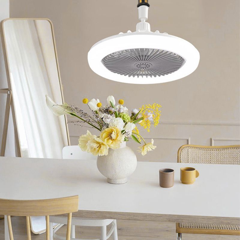 Ceiling fan above a dining table with a vase of flowers and two cups.