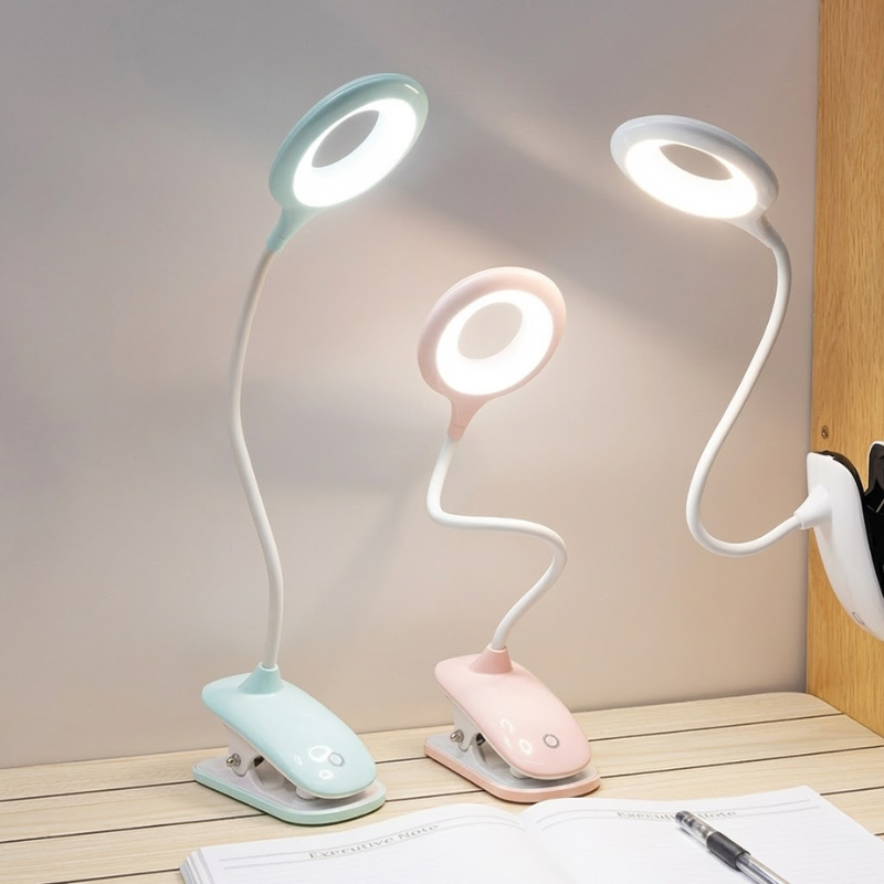 Three flexible desk lamps in different colors on a wooden surface.