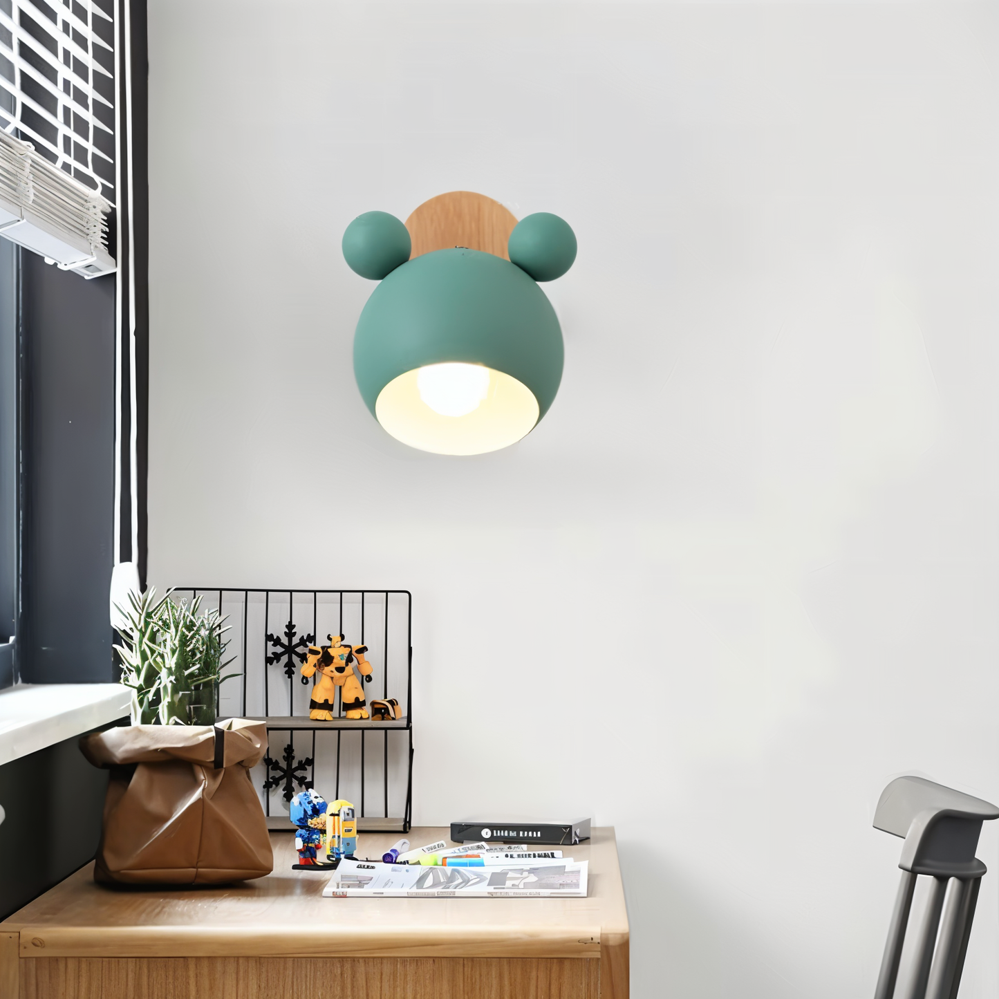 Children's room with a green and brown teddy bear-shaped lamp on a desk.